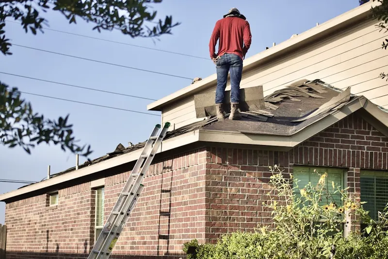 Professional roofer working on a residential roof in Windfall